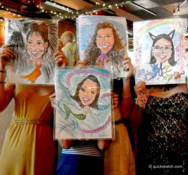 four girls holding up their caricatures over their faces